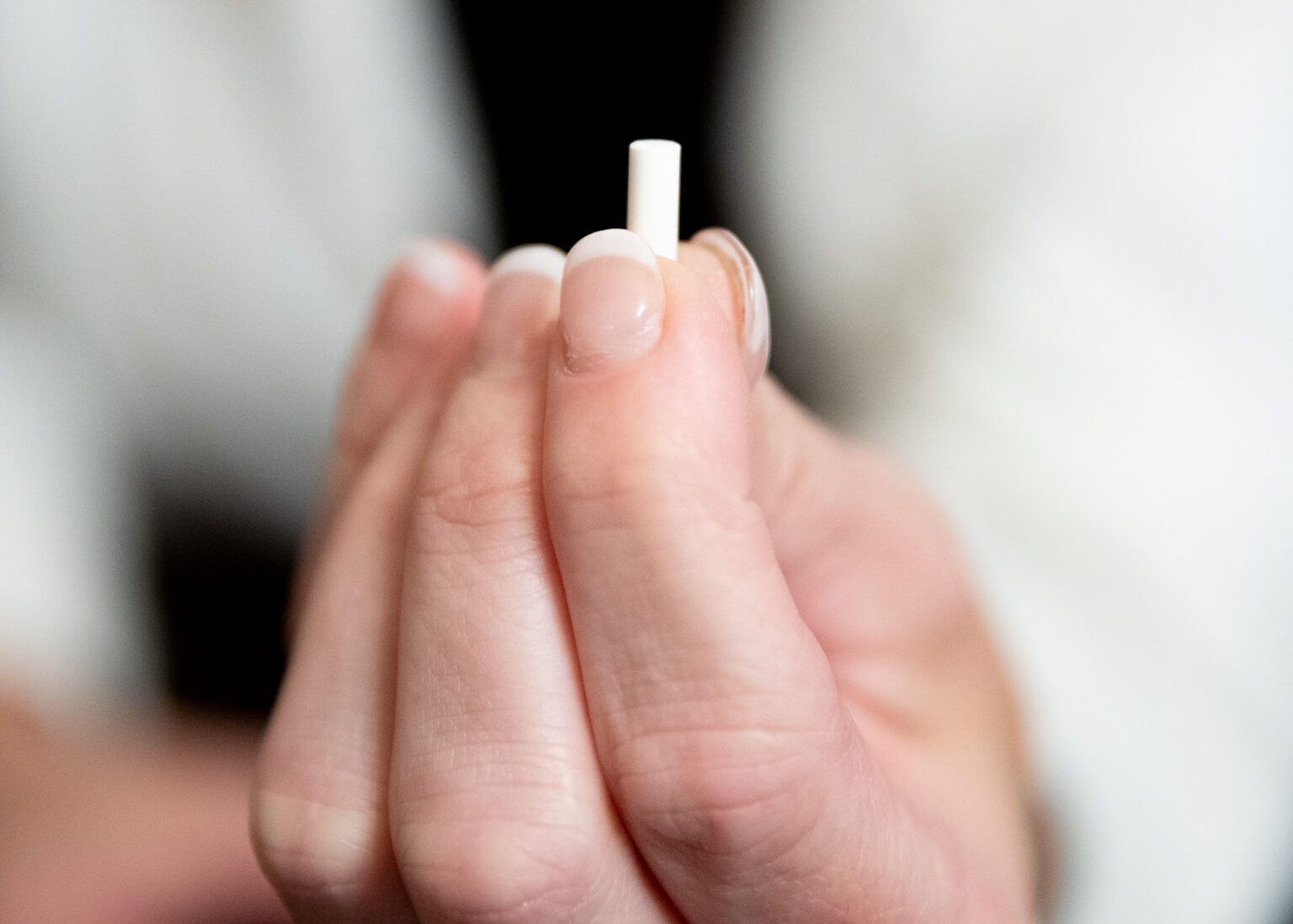 A BHRT doctor in Lenexa holds up a tiny pellet used in bioidentical hormone replacement therapy.