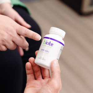 A close up of a provider holding a bottle of supplements for bioidentical hormone replacement therapy near Overland Park.