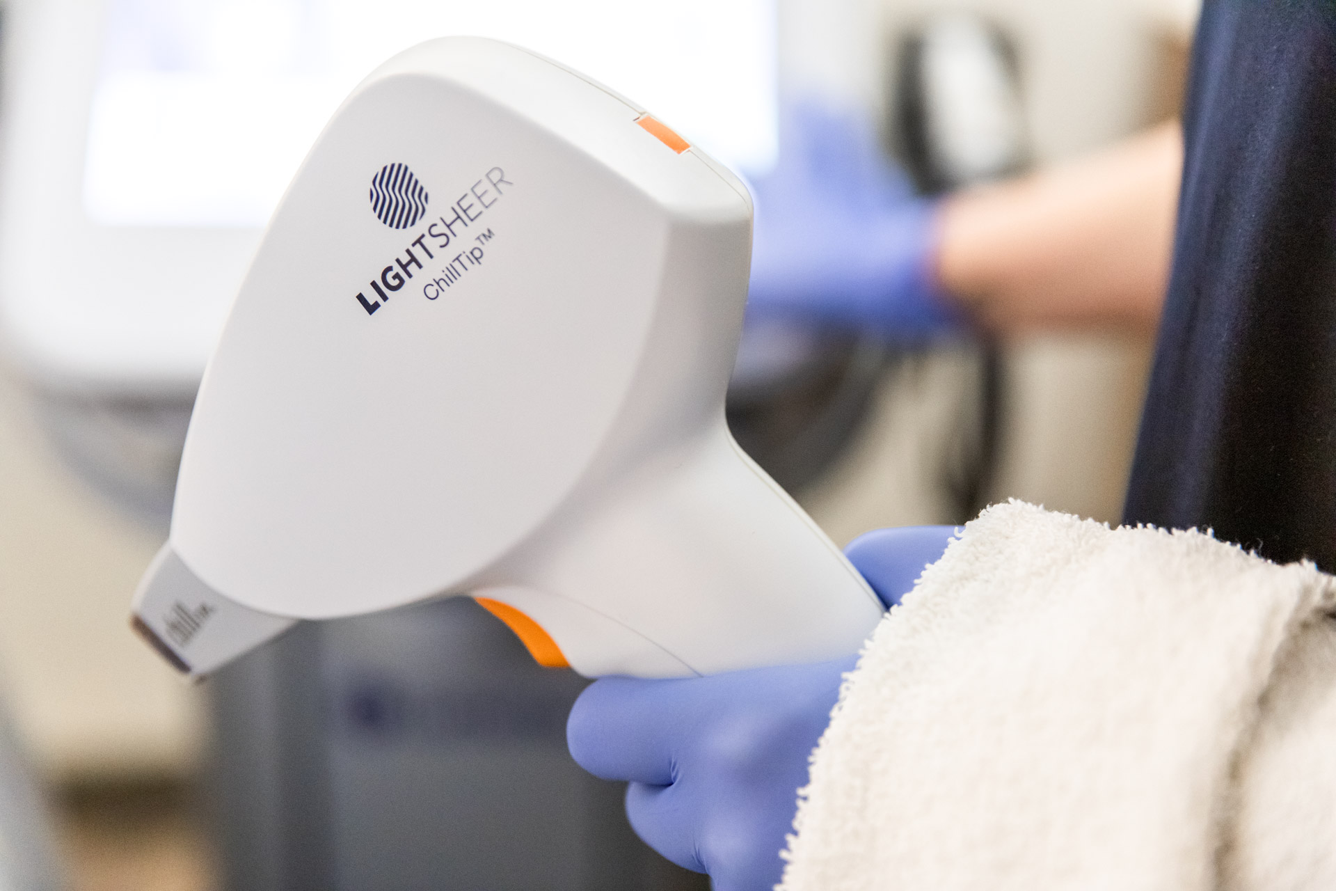 A provider at Physician Aesthetic Specialists holds up a device for laser hair removal near Overland Park.
