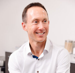 A provider in a white shirt smiles after administering bioidentical hormone replacement therapy near Overland Park.